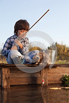 Happy boy go fishing on the river with pet, one children and kit