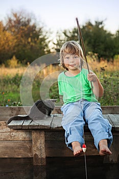 Happy boy go fishing on the river with pet, one children and kit