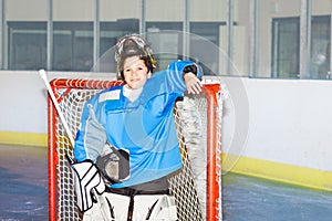 Happy boy goaltender posing after hockey match photo