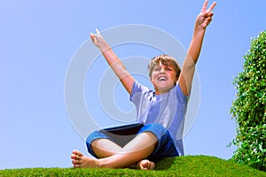Happy boy on the grass with tablet computer
