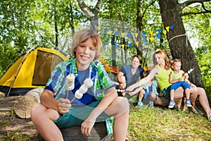 Happy boy with grilled marshmallow at the campsite