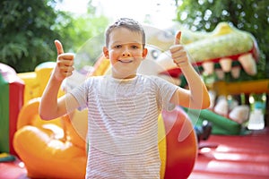 Happy boy having a lots of fun on a colorful inflate castle