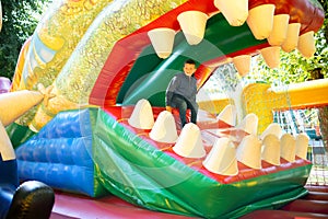 Happy boy having a lots of fun on a colorful inflate castle