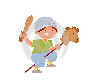 Happy boy in a helmet rides a toy horse and holds a wooden sword. childrens games in the knight