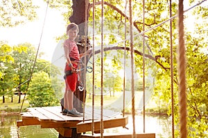 Happy boy on the high tree platform at rope park