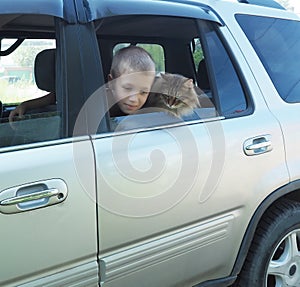 Happy boy and his companion cat in the car