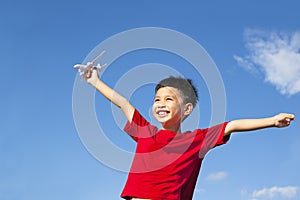 Happy boy holding a airplane toy and open arms