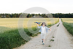 Happy boy holding airplane toy during running