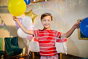 Happy boy holding balloons during birthday party