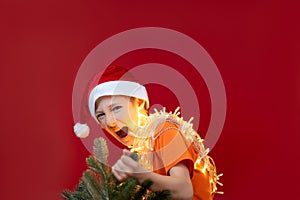 Happy boy holding a christmas tree in his hands and is happy to have caught it