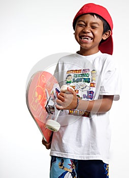 Happy boy holding his skateboard