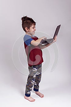 Happy boy holding a laptop and learning