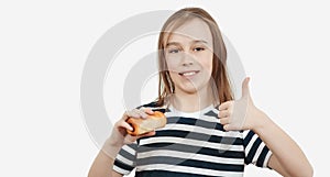 Happy boy holding tasty bun with sausage. Hungry boy eating snack