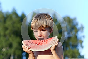 Happy boy holding watermelon on nature background