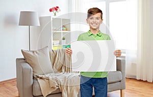 Happy boy holding white blank paper sheet at home