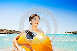 Happy boy with inflatable float on tropical beach