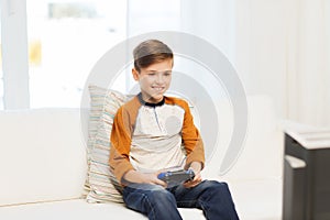 Happy boy with joystick playing video game at home