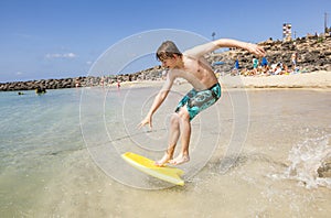 Happy boy is jumping into the ocean in Lanzarote