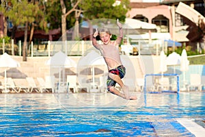 Happy boy jumping in swimming pool
