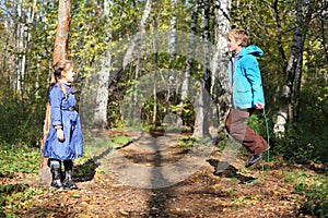 Happy boy jumps with skipping rope and girl looks at him