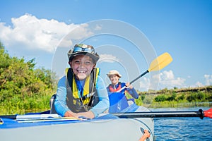 Happy boy kayaking on the river on a sunny day during summer vacation