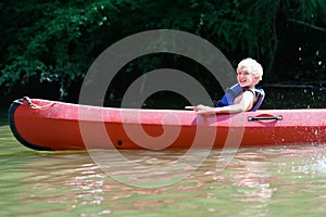 Happy boy kayaking on the river