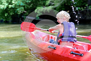 Happy boy kayaking on the river