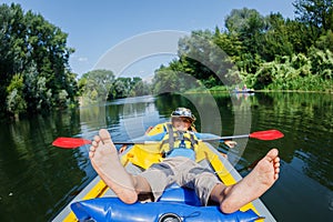 Happy boy kayaking on the river on a sunny day during summer vacation