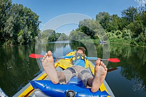 Happy boy kayaking on the river on a sunny day during summer vacation