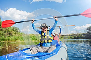 Happy boy kayaking on the river on a sunny day during summer vacation