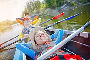 Happy boy kayaking on the river on a sunny day during summer vacation