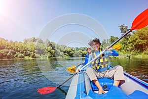 Happy boy kayaking on the river on a sunny day during summer vacation