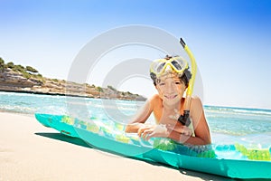 Happy boy laying on air mattress after snorkeling