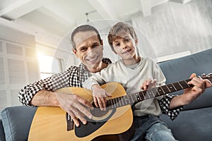 Happy boy learning to play the guitar