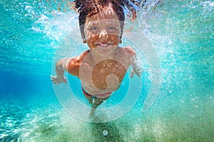 Happy boy learning to swim underwater