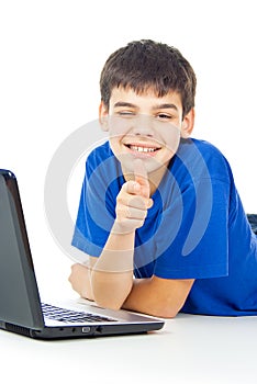 Happy boy learns lessons at a laptop