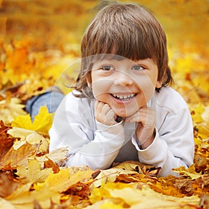 Happy boy in leaves