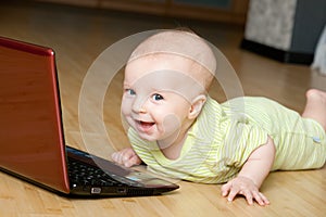 Happy boy lies on the floor with notebook