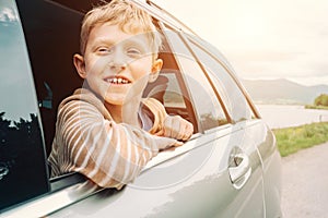 Happy boy look out from window car