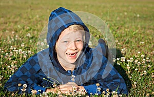 Happy boy lying in grass smiling