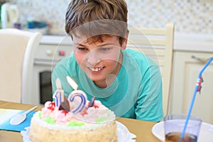 Happy boy makes a wish before blow out a candle on photo