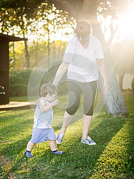 Happy boy making funny faces and expressions while walking with his grandmother