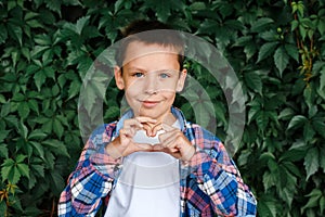 Happy boy making a heart shape with his hands