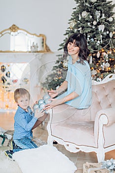 Happy boy with mather near Christmas tree