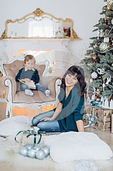 Happy boy with mather near Christmas tree