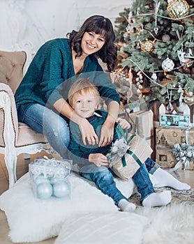 Happy boy with mather near Christmas tree