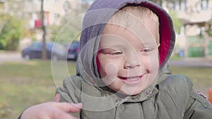 Happy boy on merry-go-round in park. Carousel