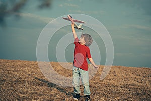 Happy boy play in airplane outdoors. Concept of dreams and travels. Dreams of flying planes. Kids having fun with toy