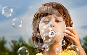 Happy Boy play in bubbles in field sunny summer day