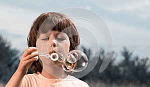 Happy boy play in bubbles outdoors